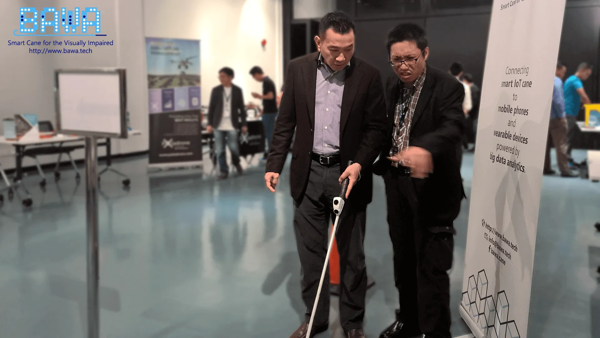 Dato Loh Yuen Tuck from The IoT Solutions Sdn Bhd listens on while Daniel Vong is explaining how to use a white cane.